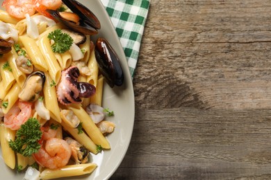 Delicious pasta with sea food on wooden table, top view. Space for text