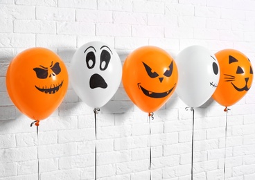 Photo of Color balloons for Halloween party against white brick wall