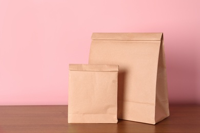 Paper bags on table against color background. Mockup for design