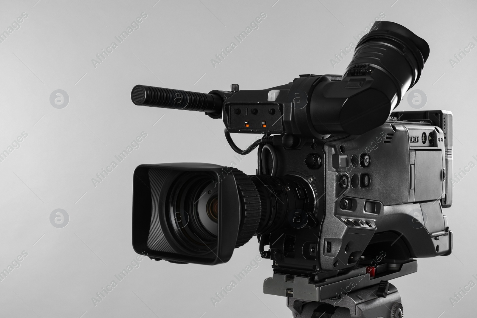 Photo of Modern professional video camera on light background