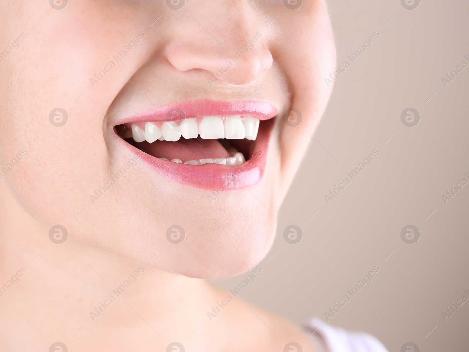 Photo of Young woman with beautiful smile on color background, closeup. Space for text