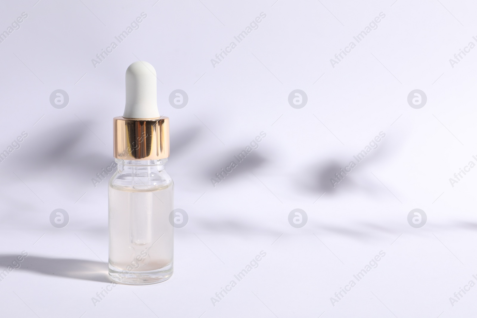 Photo of Bottle of cosmetic serum on white background. Space for text