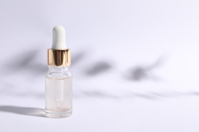 Bottle of cosmetic serum on white background. Space for text