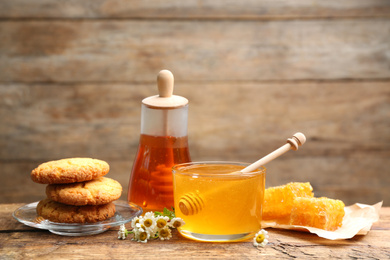 Composition with tasty honey on wooden table