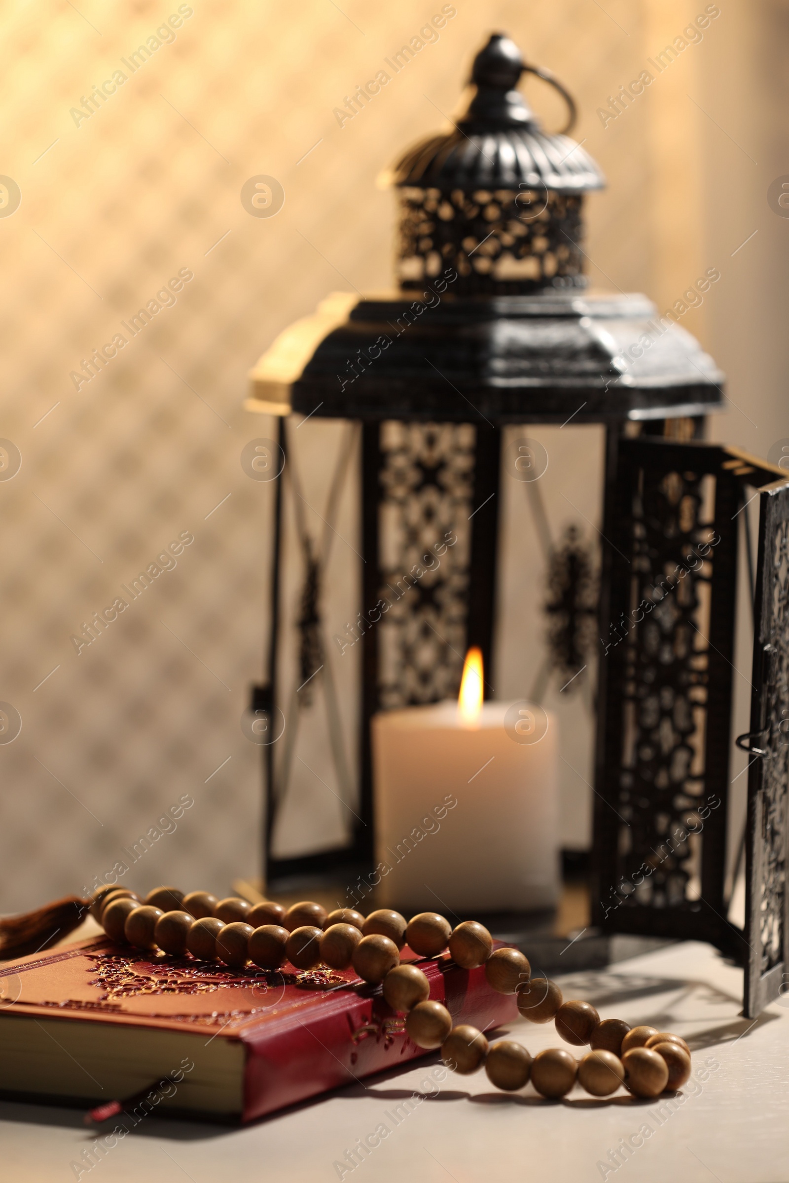 Photo of Arabic lantern, Quran and misbaha on white table