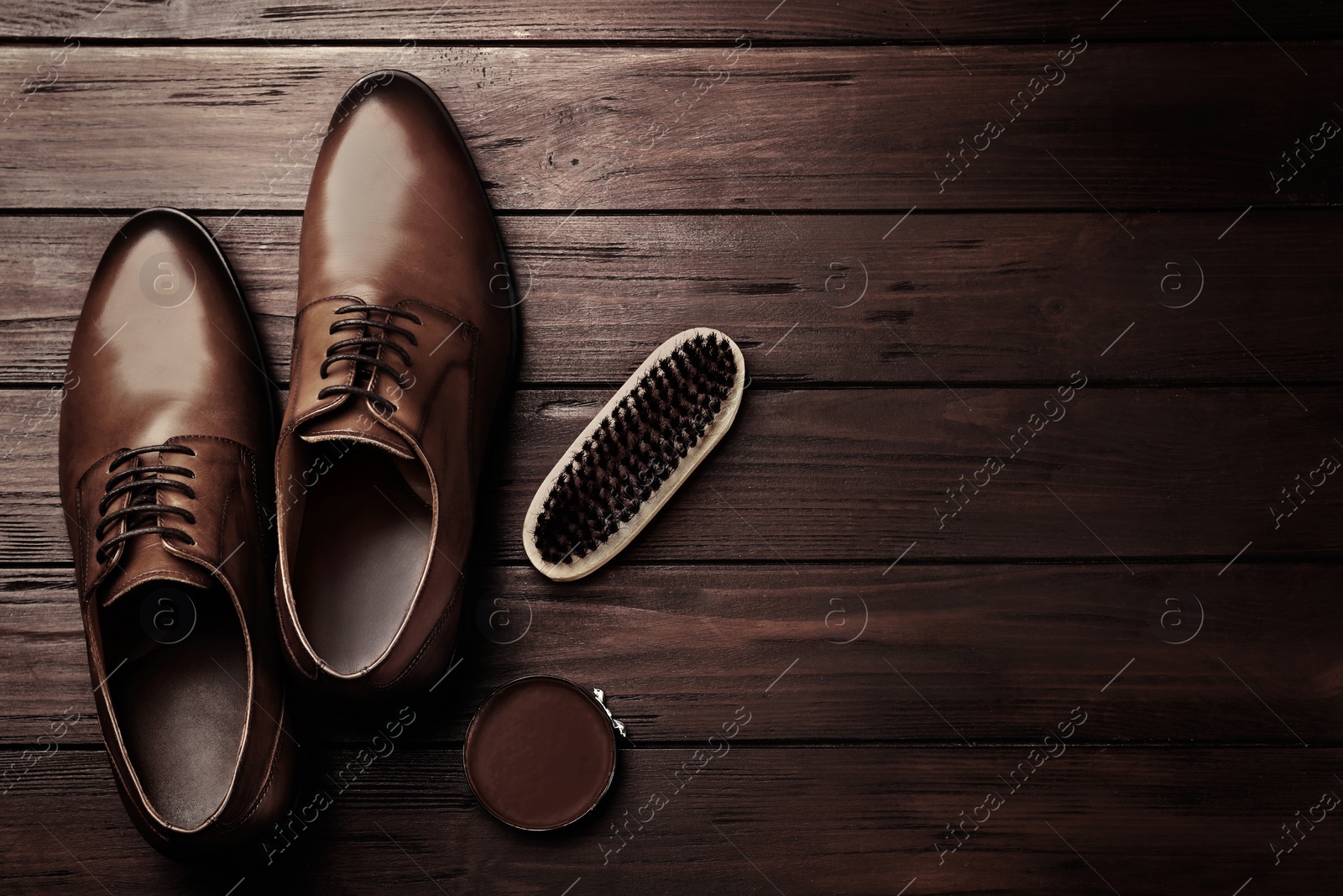 Image of Flat lay composition with shoe care accessories and footwear on wooden background. Space for text