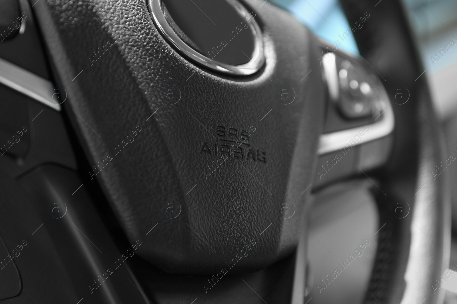 Photo of Safety airbag sign on steering wheel inside car, closeup