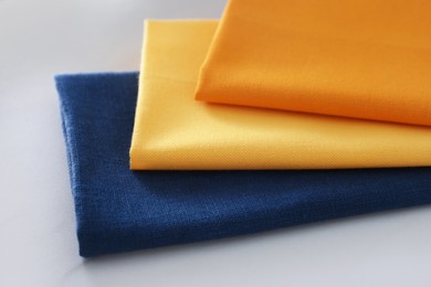 Photo of Different colorful napkins on white table, closeup