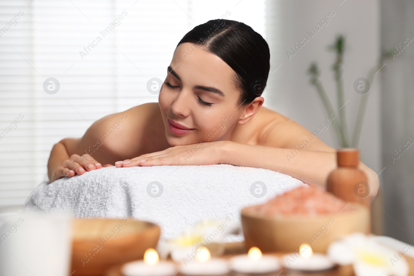 Photo of Beautiful woman relaxing on massage table in spa salon