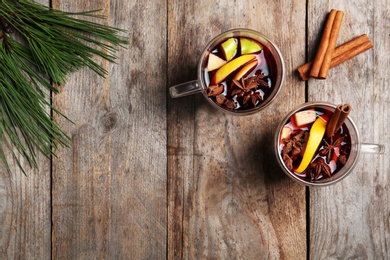 Photo of Flat lay composition with glasses of hot mulled wine on wooden background