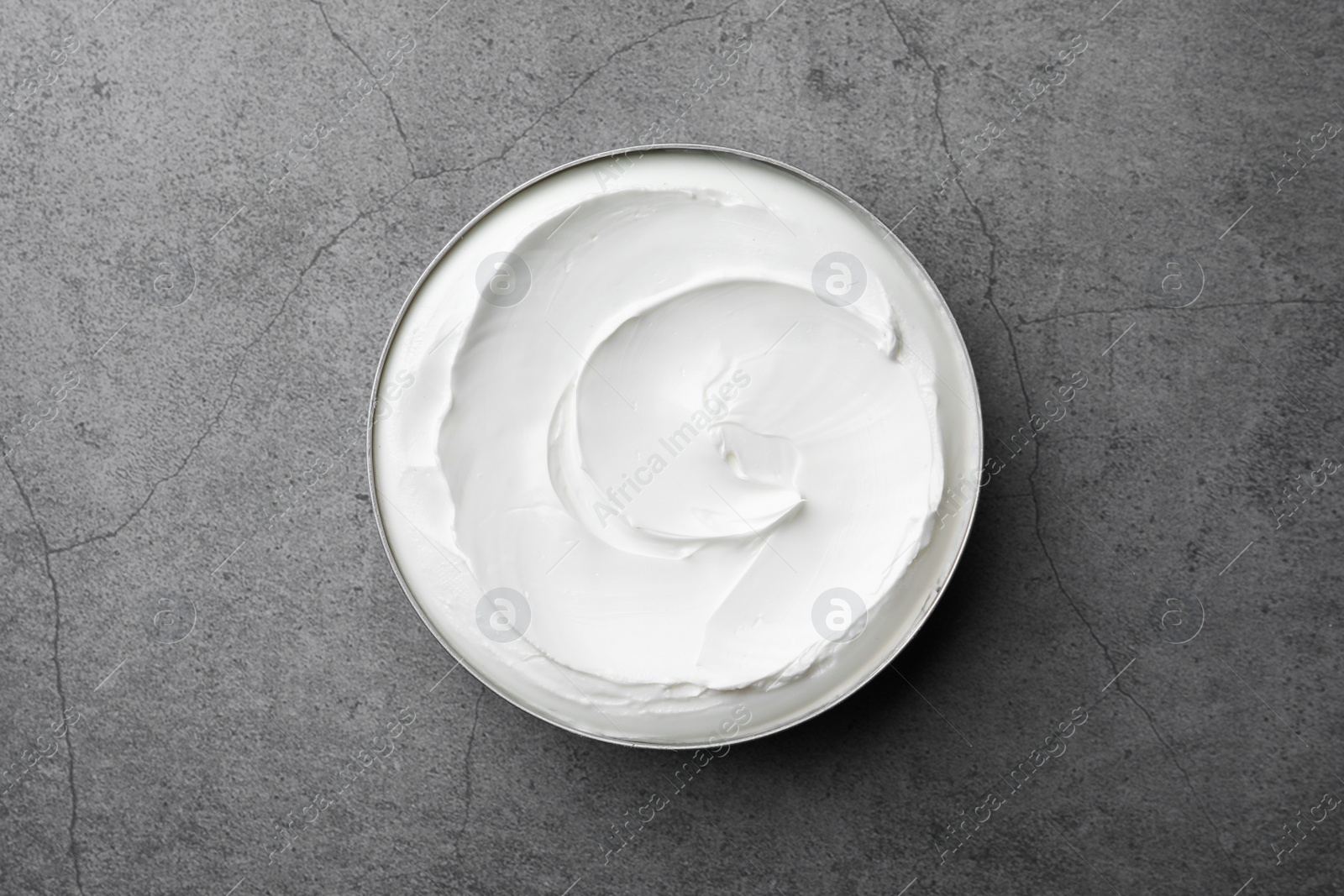 Photo of Jar of face cream on grey table, top view