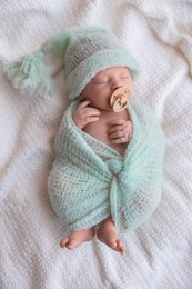 Photo of Cute newborn baby sleeping on white plaid, top view