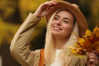 Portrait of happy woman with autumn leaves outdoors