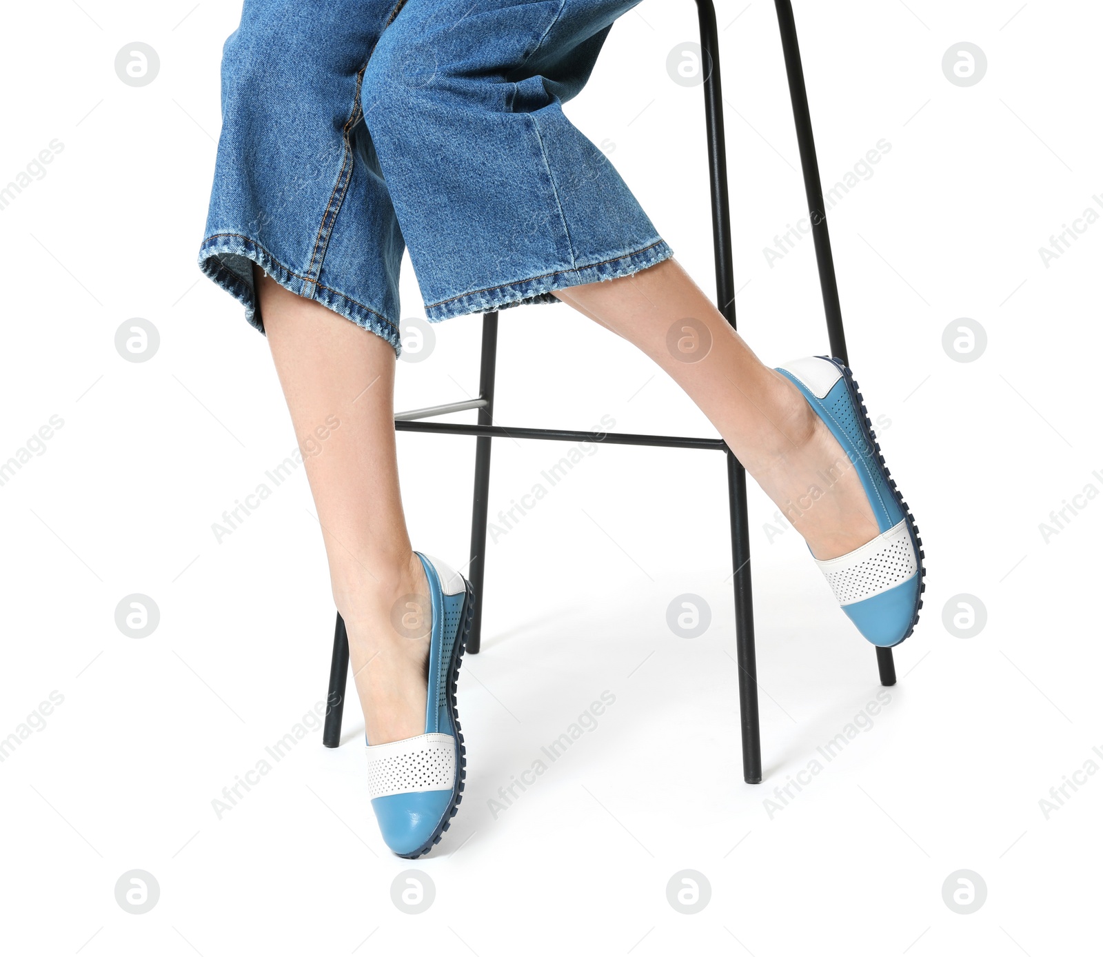 Photo of Woman in stylish shoes on stool against white background, closeup