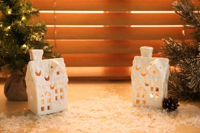 Photo of Beautiful house shaped Christmas lanterns with burning candles on window sill