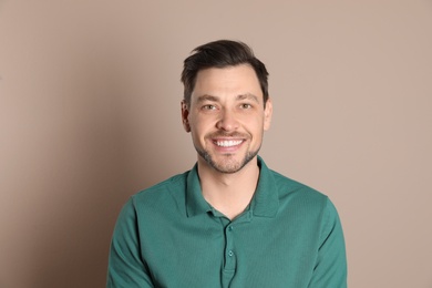 Smiling man with perfect teeth on color background