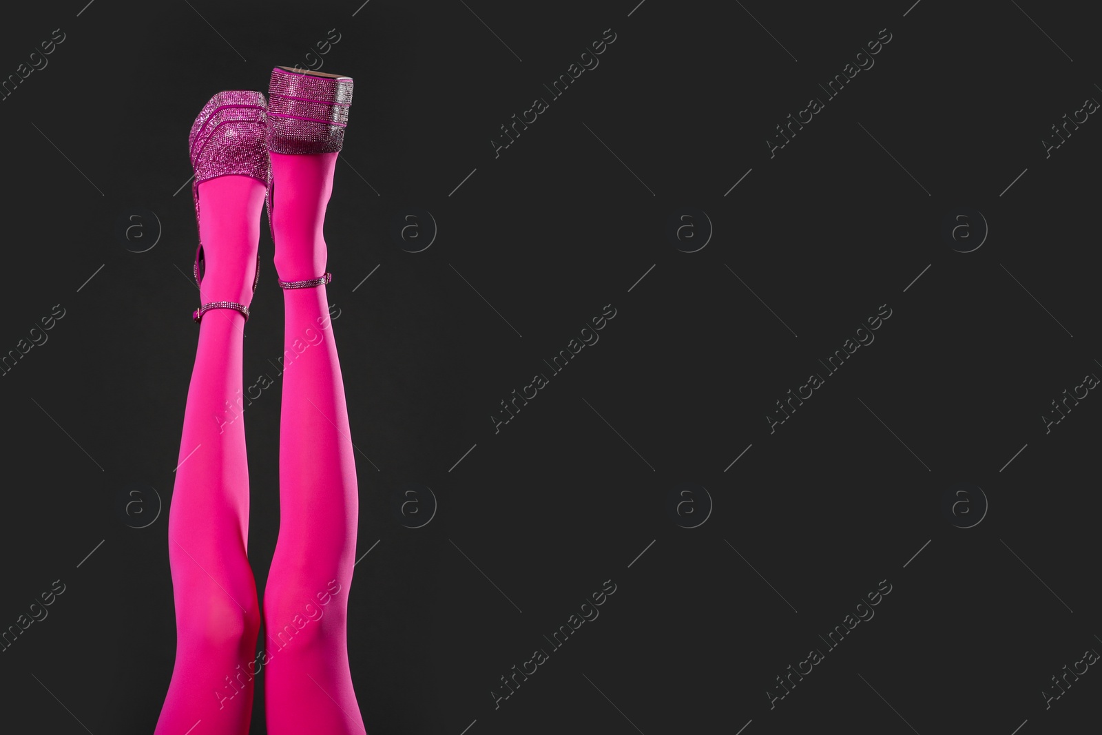 Photo of Woman wearing pink tights and high heeled shoes with platform and square toes on black background, closeup. Space for text