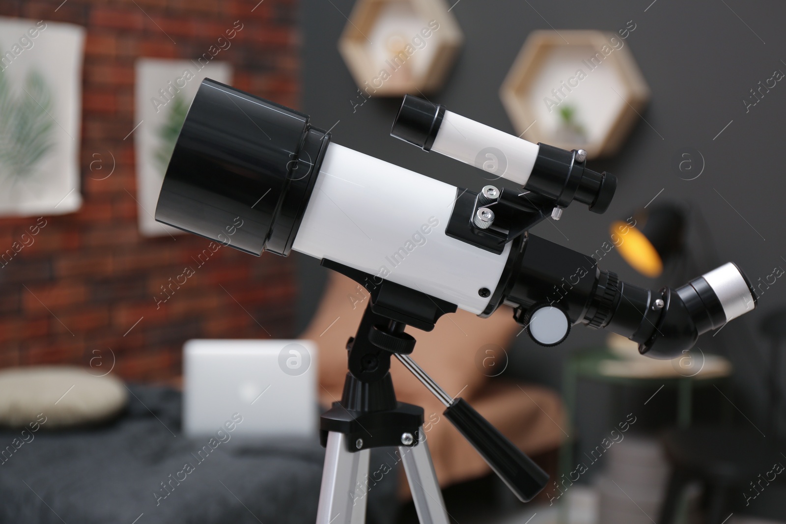 Photo of Tripod with modern telescope in stylish room, closeup