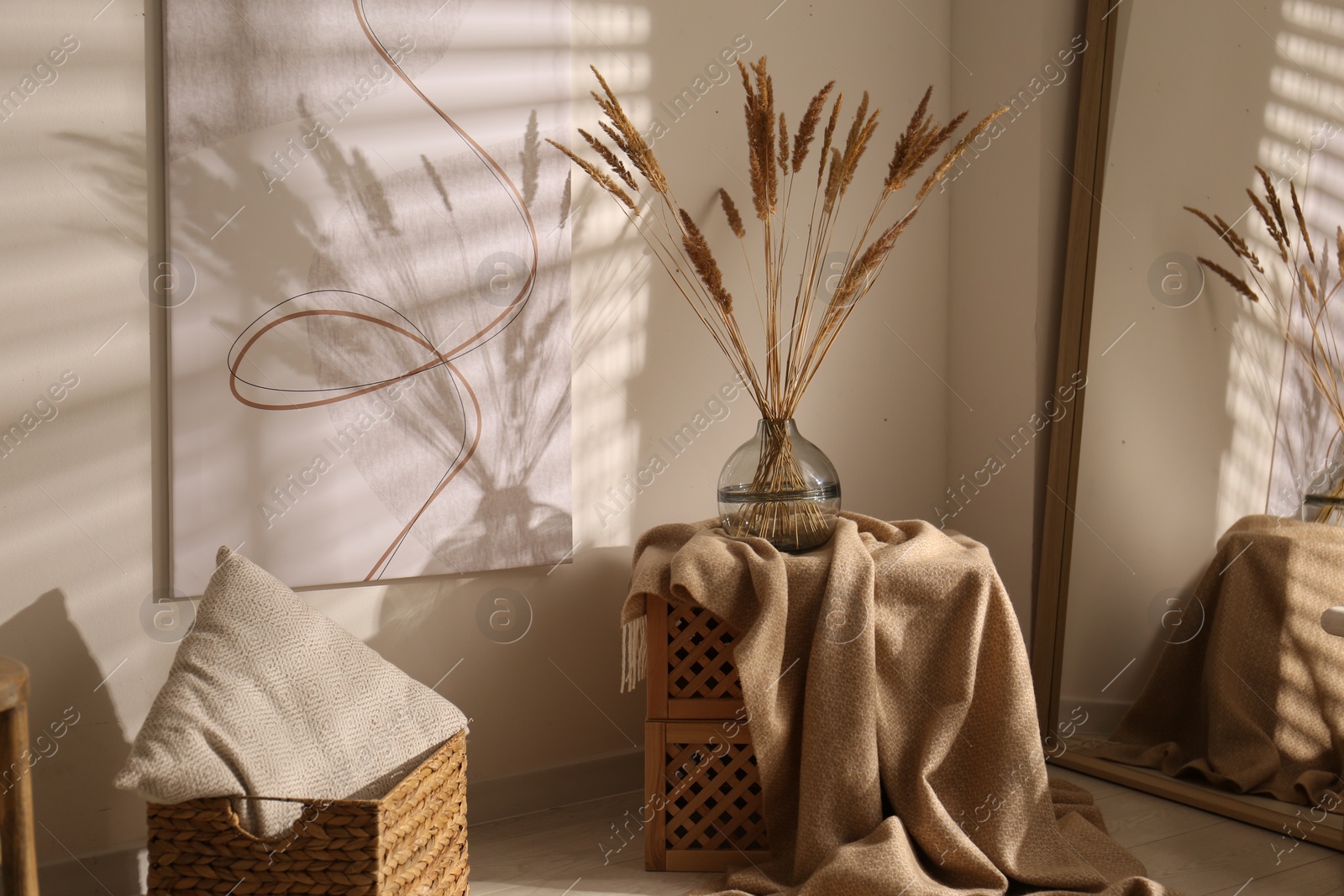 Photo of Vase with decorative dried plants and painting in stylish room interior