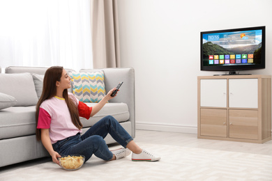 Image of Woman watching smart TV in living room