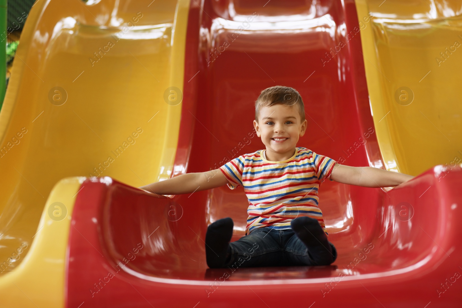 Photo of Cute little child playing at indoor amusement park