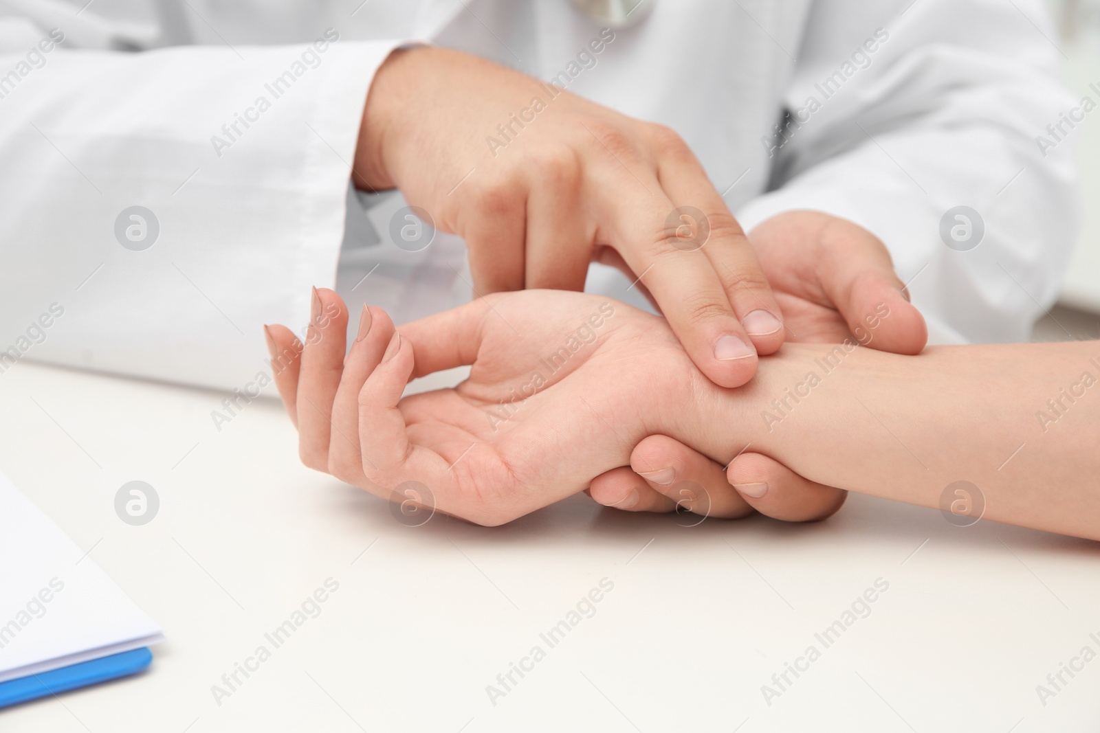 Photo of Doctor checking young woman's pulse in hospital