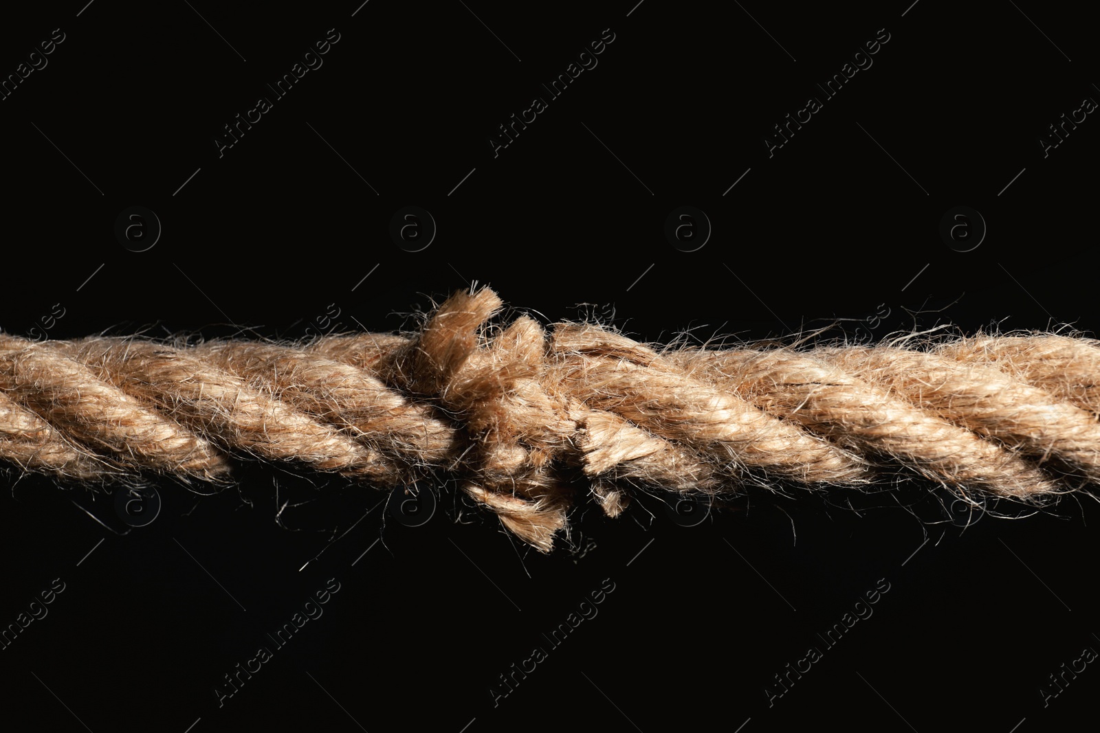 Photo of Rupture of cotton rope on black background