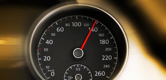 Speedometer on car dashboard, closeup. Motion blur effect. Banner design