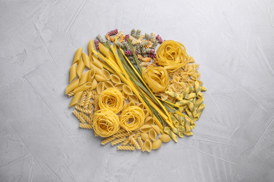 Photo of Different types of pasta on light grey table, flat lay
