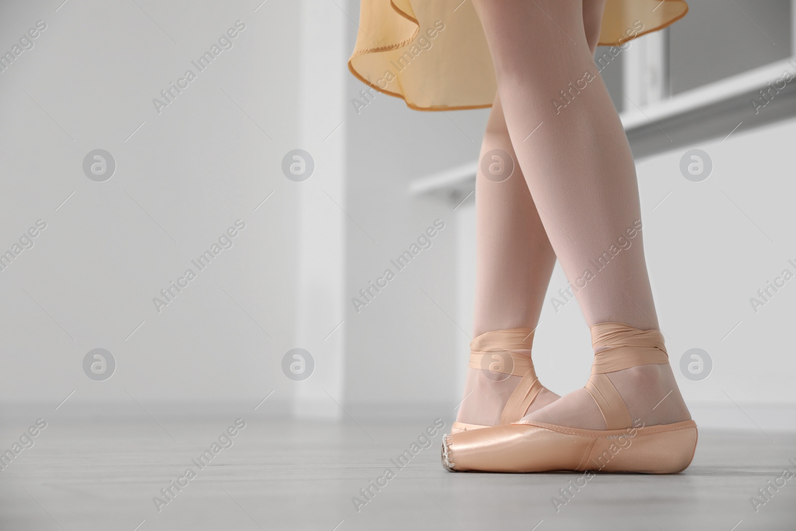 Photo of Ballerina in pointe shoes dancing indoors, closeup. Space for text