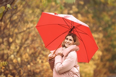 Woman with umbrella in autumn park on rainy day