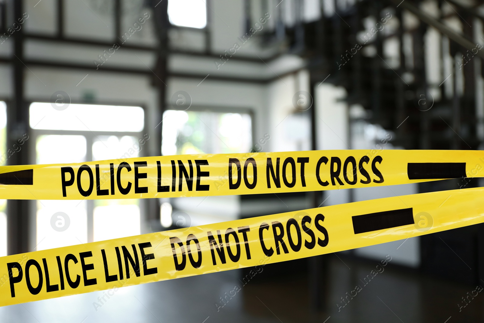 Image of Yellow crime scene tape blocking way indoors