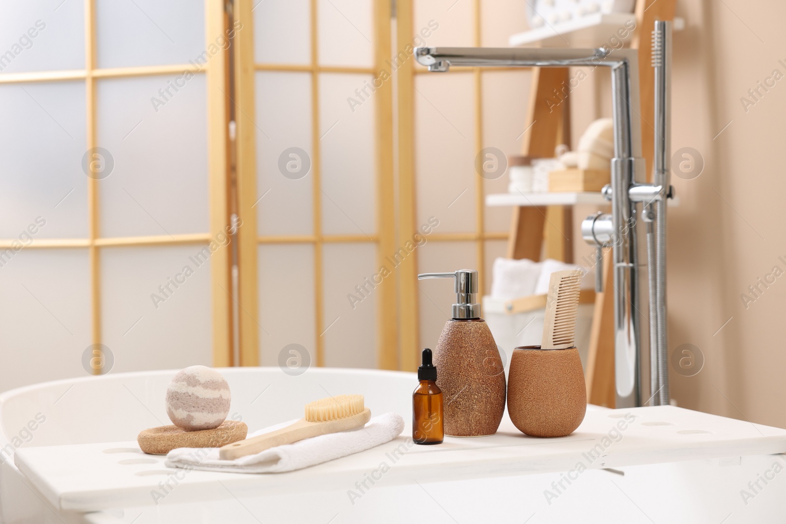 Photo of Different personal care products and accessories on bath tub in bathroom