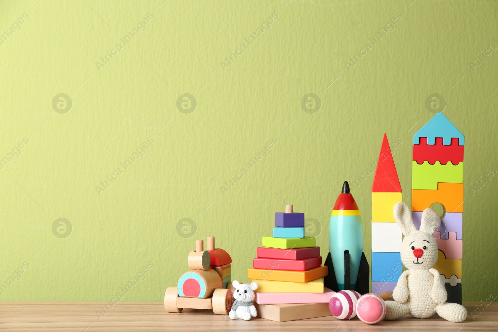 Photo of Set of different toys on wooden table. Space for text