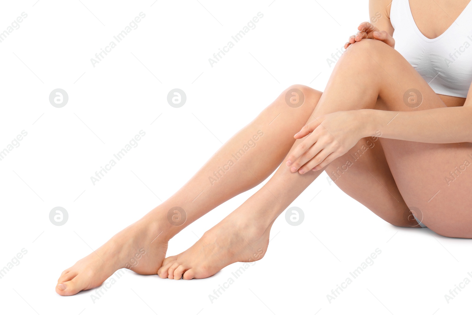 Photo of Young woman with perfect smooth skin on white background, closeup of legs. Beauty and body care