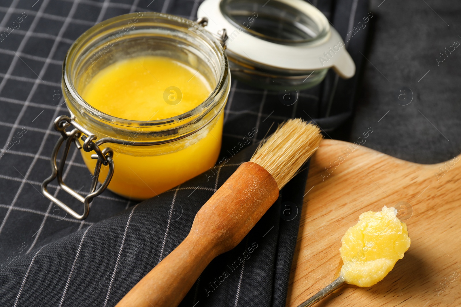 Photo of Composition with clarified butter and basting brush on table