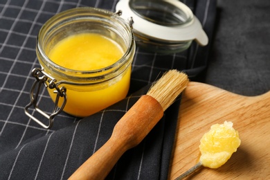 Photo of Composition with clarified butter and basting brush on table