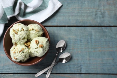 Photo of Delicious pistachio ice cream served on blue wooden table, flat lay