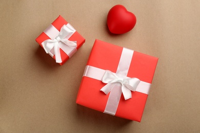 Photo of Beautiful gift boxes and red heart on brown background, flat lay. Valentine's day celebration