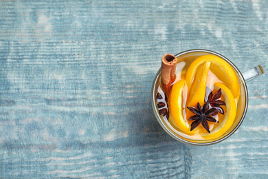 Photo of Aromatic mulled wine on light blue wooden table, top view. Space for text