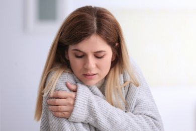 Sad woman suffering from cold on blurred background