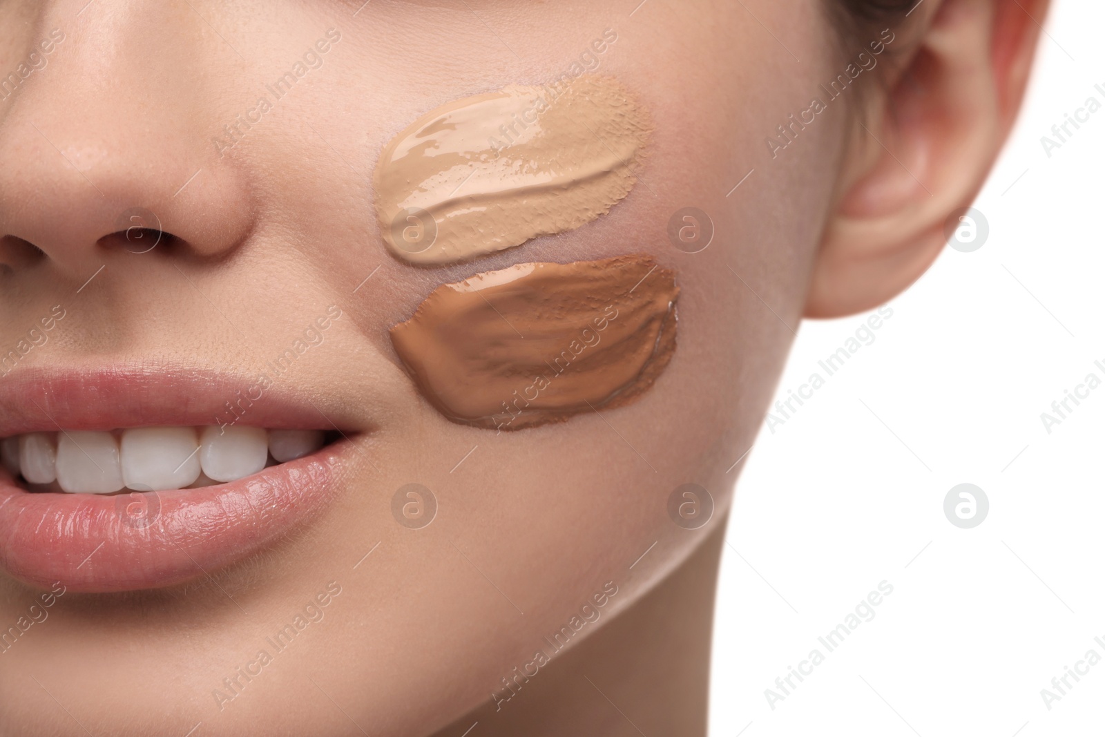 Photo of Teenage girl with swatches of foundation on face against white background, closeup