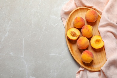 Plate with delicious ripe peaches on grey background, top view