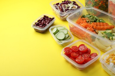 Set of plastic containers with fresh food on yellow background, space for text