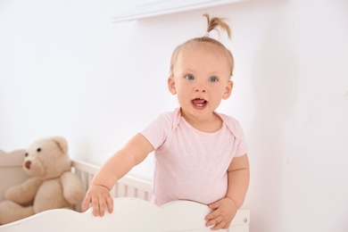 Photo of Adorable baby girl in her crib at home