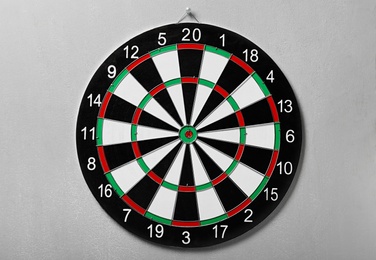 Dart board hanging on grey concrete wall