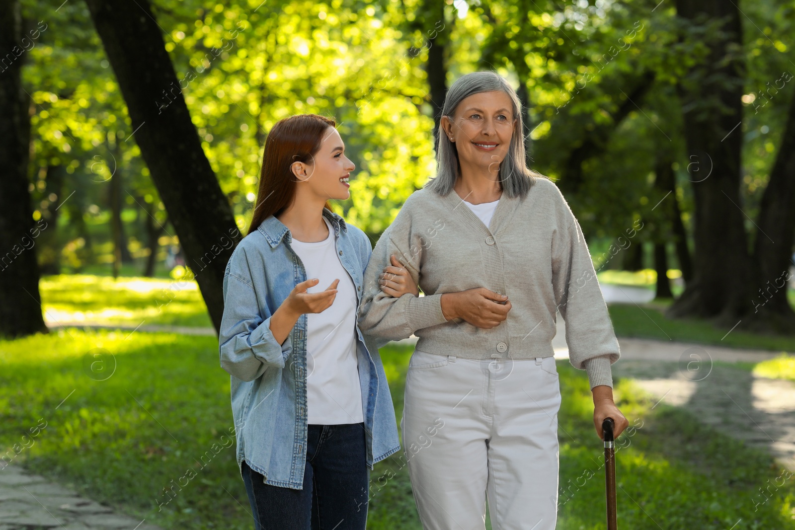 Photo of Senior lady with walking cane and young woman in park