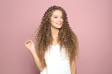 Photo of Portrait of beautiful young woman with shiny wavy hair on color background