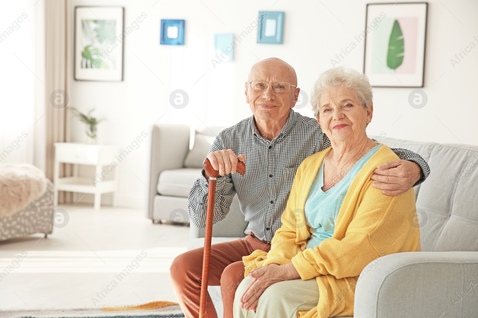 Photo of Elderly couple sitting on couch in living room