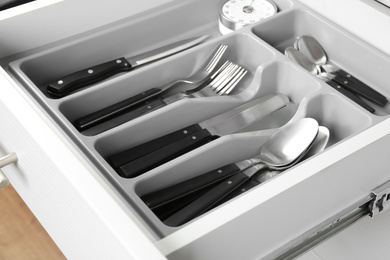 Photo of Open drawer with different utensils. Order in kitchen